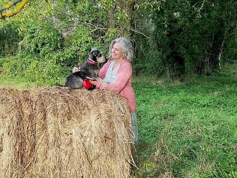 Celia y Mushu mirándose, subidos a una bala de paja en el campo