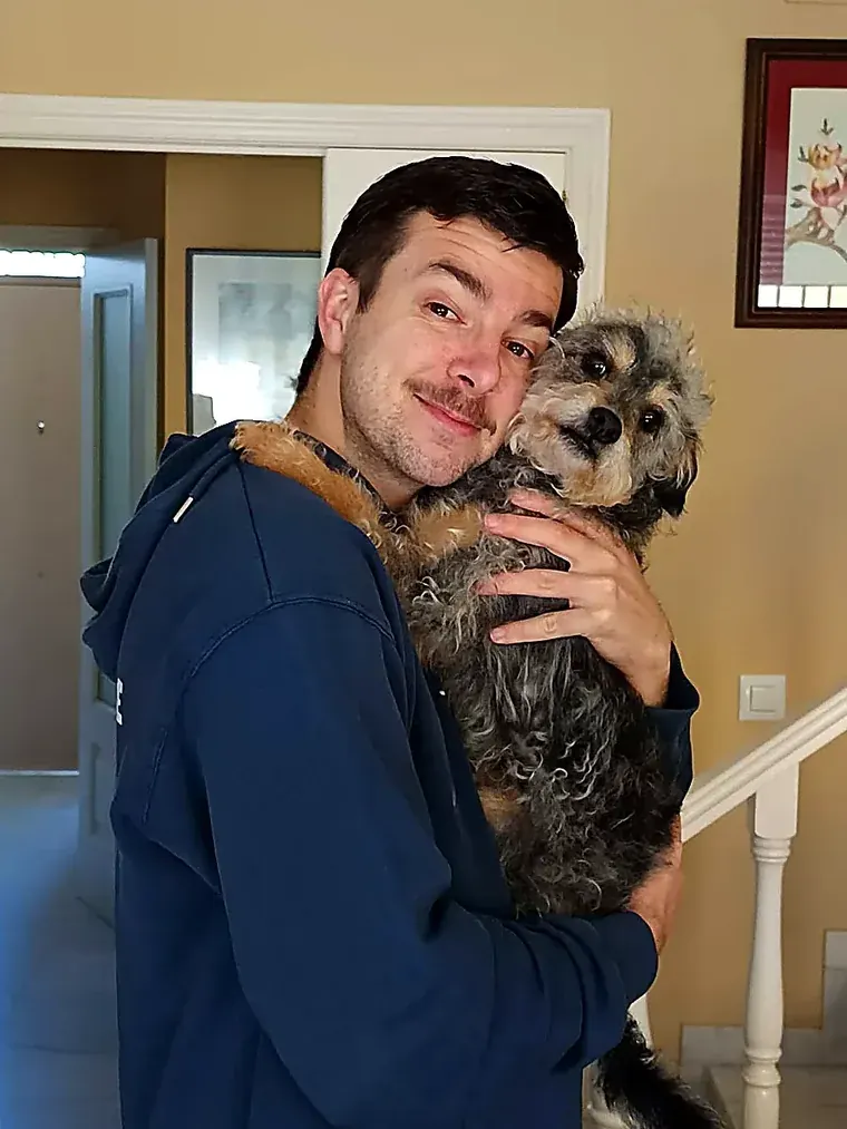 Mushu en brazos, apoyando la cabeza en la cara de su familia